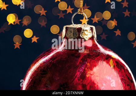 Rote weihnachtskugel mit goldenen Lichtern auf dunkelblauem Hintergrund Stockfoto