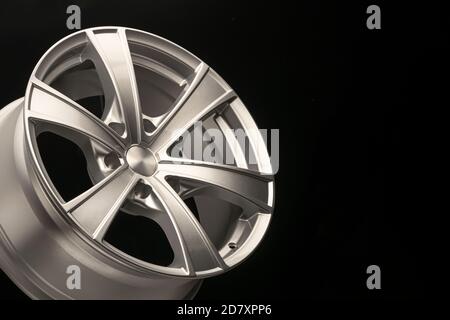 Silbernes Leichtmetallrad für Crossovers und SUVs auf dunklem Hintergrund, Nahaufnahme. Platz für Werbung und Werbetext kopieren Stockfoto