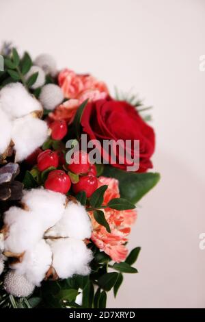 Bouquet mit roten Rosen, Baumwollkugeln, Zapfen, Fichte und anderen Blumen. Kreis Blumen Bündel. Nahaufnahme Stockfoto