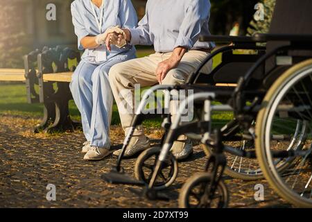 Patient, der Rollstuhl benutzt, erhält Unterstützung von einem Freiwilligen Stockfoto