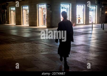 Barcelona, Spanien. Oktober 2020. 25. Oktober 2020, Barcelona, Katalonien, Spanien: Eine Frau spaziert einige Minuten vor Beginn der Ausgangssperre durch die einsamen Straßen Barcelonas. Der spanische Premierminister hat heute einen neuen Ausnahmezustand genehmigt, der bis Mai in Kraft bleiben soll, und die katalanische Regierung verhängt zwischen 22 und 6 Uhr eine obligatorische Ausgangssperre. Quelle: Jordi Boixareu/Alamy Live News Stockfoto