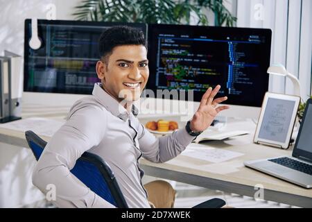 Softwareentwickler winkt an der Kamera Stockfoto