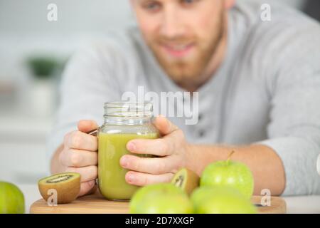 Gesunder Mann trinkt einen grünen Saft detox glattig Stockfoto