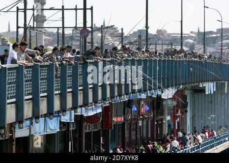 Hunderte von Fischern warfen ihre Linien in das Goldene Horn von der Galata-Brücke in Istanbul in der Türkei. Angeln ist ein beliebter Zeitvertreib der Türken. Stockfoto