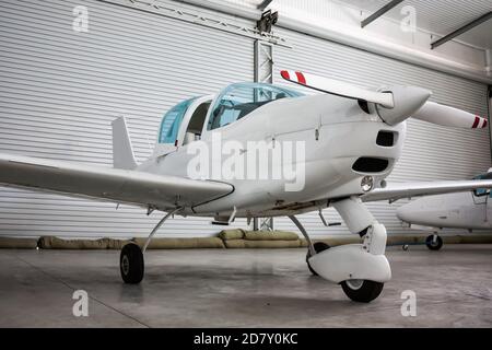 Kleines Sportflugzeug mit geöffnetem Cockpit-Baldachin im Hangar Stockfoto