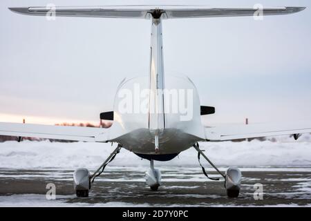 Rückansicht des kleinen Sportflugzeugs im Winter Flugplatz bei Sonnenuntergang Stockfoto
