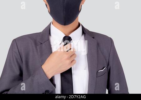 Nahaufnahme junger asiatischer Geschäftsmann in Anzug trägt Gesichtsmaske für Schutz covid-19 isoliert auf weißem Hintergrund, Geschäftsmann Hand hält Hals Krawatte, qu Stockfoto