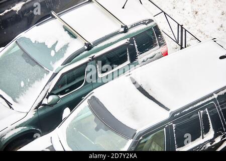 Autos mit Schnee im Winter auf einem Parkplatz bedeckt. Stockfoto