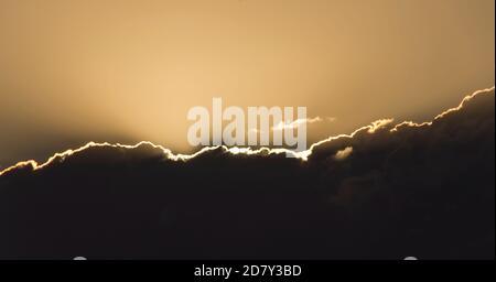 Sonnenuntergang. Sonne hinter grauen Wolken, die einen silbernen Lining-Effekt erzielen. Frühling, Queensland, Australien. Hintergrund, Kopierbereich. Stockfoto