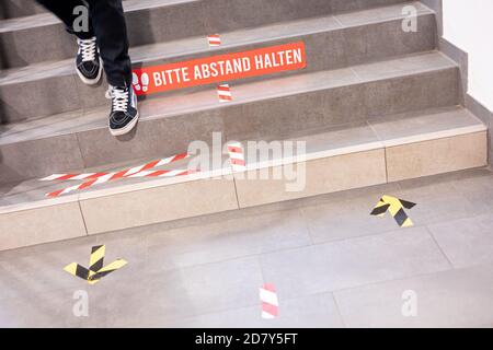 Hannover, Deutschland. Oktober 2020. Die Beschriftung 'Bitte Abstand halten' und andere Wegmarkierungen sind auf einer Treppe in der Otfried-Preußler-Schule zu sehen. In Niedersachsen beginnt der Schulunterricht heute nach den Herbstferien wieder. Quelle: Moritz Frankenberg/dpa/Alamy Live News Stockfoto