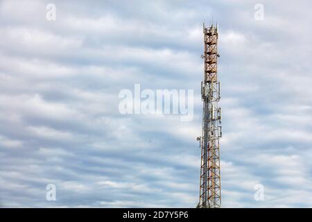 Hoher Telekommunikationsturm von 3G, 4G und 5G Mobilfunk mit Antennen gegen blauen bewölkten Himmel, Kopierraum. Stockfoto