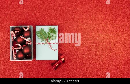 Offene Box mit Weihnachtsdekoration auf rotem Hintergrund. Speicherplatz kopieren. Stockfoto