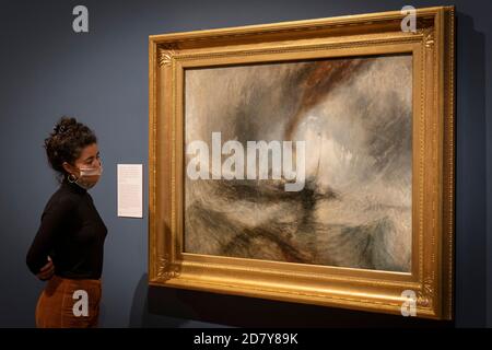 London, England. Oktober 2020. Eine Mitarbeiterin der Tate Britain, die Turners ikonisches Öl auf Leinwand bei der Pressekonferenz in der Tate Britain mit den Bildern Rain, Steam und Speed betrachtet. Am 28. Oktober 2020 eröffnet die große Ausstellung JMW Turner (1775-1851). Turner’s Modern World zeigt, wie der britische Landschaftsmaler neue Wege gefunden hat, alltägliche Ereignisse einzufangen, von den Auswirkungen der Technologie auf die Natur bis hin zu den Auswirkungen der Modernisierung auf die Gesellschaft. (Foto von Sam Mellish / Alamy Live News) Stockfoto