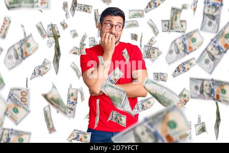 Junge hispanische Mann trägt Freizeitkleidung und Brille gestresst und nervös mit Händen auf Mund beißen Nägel. Angst Problem. Stockfoto