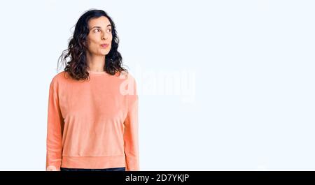 Junge schöne hispanische Frau trägt lässige Kleidung lächelnd Blick zur Seite und starrte weg denken. Stockfoto