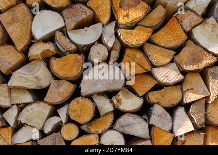 Brennholz für die Heizung im Winter geerntet. Ein Haufen Brennholz im Hof des Hauses auf dem grünen Gras Stockfoto