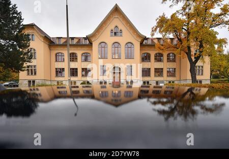 26. Oktober 2020, Thüringen, Weimar: Das Max-Zöllner-Haus spiegelt sich im nassen Dach eines Autos. Hier findet am Montag eine Anhörung des Thüringer Verfassungsgerichts statt. Das Landesverfassungsgericht verhört eine Klage der Thüringer AfD gegen die härtekommission des Landes. Nach Angaben des Migrationsministeriums kann die kommission den Flüchtlingen und anderen Ausländern, die das Land verlassen müssen, eine Aufenthaltserlaubnis erteilen. Bei den Entscheidungen spielten humanitäre oder persönliche Gründe eine Rolle. Eine Entscheidung wird für Dezember erwartet. Foto: Mart Stockfoto