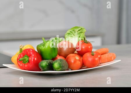 Nahaufnahme einer Auswahl an frischem Gemüse auf einem Teller auf einem unscharf Hintergrund. Konzept für frische Lebensmittel und Gemüse. Stockfoto