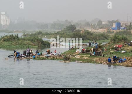Blick auf afrikanische Frauen, die Kleidung waschen, und sich selbst im Niger, Mali, Bamako, Westafrika Stockfoto