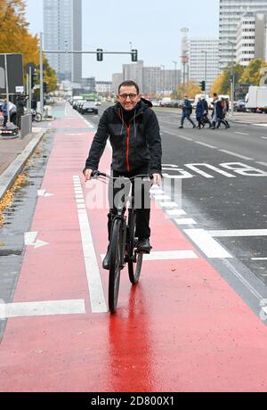 26. Oktober 2020, Berlin: Stephan von Dassel (Bündnis 90/die Grüne), Bezirksbürgermeister von Berlin Mitte, fährt mit dem Fahrrad auf der neu gestalteten Karl-Marx-Allee mit breiten Fahrradwegen, besseren Kreuzungsmöglichkeiten für Fußgänger und einem bald grünen Zentralreservat. Die Sektion wurde heute nach 28 Monaten Bauzeit übergeben. Der Umbau der Hauptstraße zwischen Strausberger Platz und Otto-Braun-Straße wurde zugunsten des Fußgänger- und Fahrradverkehrs durchgeführt. Statt Parkplätze gibt es beispielsweise eine Grünfläche in der Mitte der Karl-Marx-Allee. Foto: Jens K Stockfoto