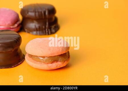 Makronen mit Dulce de leche Füllung im Vordergrund, im Hintergrund brasilianischer Honigkuchen. Stockfoto