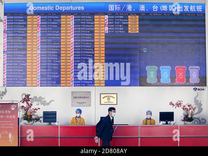 Peking, China. Oktober 2020. Am Montag, den 26. Oktober 2020, tragen Arbeiter an einem Informationsschalter im Hauptstadtflughafen in Peking Schutzmasken. Obwohl sich das tägliche Leben in China wieder normalisiert hat, sind Gesichtsmasken in Flughäfen, Bahnhöfen, Bussen und der U-Bahn immer noch erforderlich. Foto von Stephen Shaver/UPI Kredit: UPI/Alamy Live Nachrichten Stockfoto