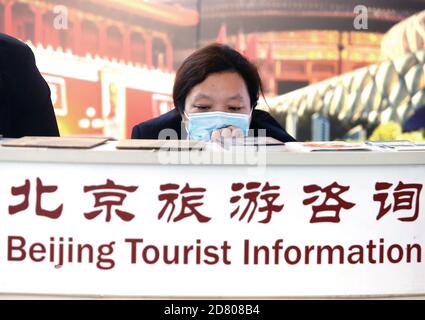 Peking, China. Oktober 2020. Am Montag, den 26. Oktober 2020, tragen Arbeiter an einem Informationsschalter im Hauptstadtflughafen in Peking Schutzmasken. Obwohl sich das tägliche Leben in China wieder normalisiert hat, sind Gesichtsmasken in Flughäfen, Bahnhöfen, Bussen und der U-Bahn immer noch erforderlich. Foto von Stephen Shaver/UPI Kredit: UPI/Alamy Live Nachrichten Stockfoto