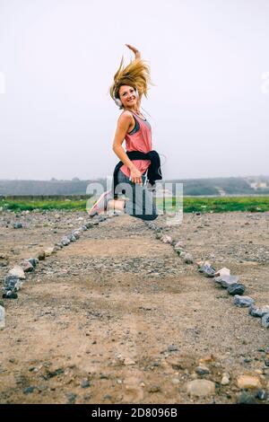 Junge Sportlerin, die auf der Straße springt Stockfoto