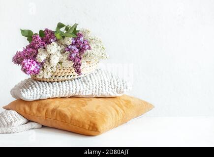 Frühling Flieder blüht im Inneren des Raumes mit dekorativen Kissen. Auf hellem Hintergrund. Stockfoto