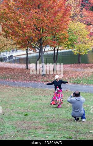 HERBSTFARBEN. Eine asiatisch-amerikanische Frau hat ihr Foto vor bunten Bäumen gemacht. In Kissena Park, Flushing, Queens, New York City. Stockfoto