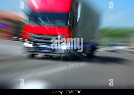 LKW mit rotem Fahrerhaus auf der Straße in Bewegung. Unfallrate. Blick aus dem Taxi des Autos Stockfoto