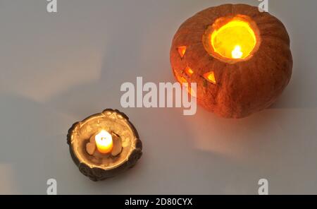 halloween Kürbis mit einer brennenden Kerze, am Kerzenständer Stockfoto