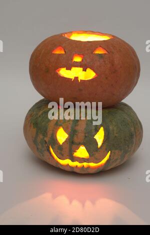 halloween Kürbis auf anderen halloween Kürbis. Geheimnisvolle rote Beleuchtung und Reflexionen. Geschnitzte gruselige Gesichter Stockfoto