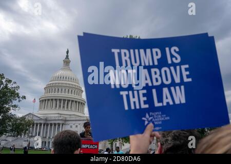 Der Protestierende hält ein Zeichen "Trump steht nicht über dem Gesetz", während der Demokrat Ilhan Omar aus Minnesota während einer Kundgebung spricht, die am Donnerstag, dem 26. September 2019, zur Unterstützung des Amtsenthebens von Präsident Donald Trump vor dem US-Kapitol in Washington, D.C., USA, stattfand. Die Demokraten im Haus haben nach einer Whistleblower-Beschwerde im Weißen Haus förmliche Anhörungen über Amtsenthebung begonnen. Quelle: Alex Edelman/The Photo Access Stockfoto