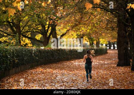 Liverpool, Großbritannien. Oktober 2020. Ein Läufer wird unter Herbstblättern in der Nähe von Sefton Park in Liverpool, Großbritannien, gesehen. Kredit: Jon Super/Alamy Live Nachrichten. Stockfoto