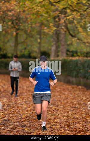 Liverpool, Großbritannien. Oktober 2020. Ein Läufer wird unter Herbstblättern in der Nähe von Sefton Park in Liverpool, Großbritannien, gesehen. Kredit: Jon Super/Alamy Live Nachrichten. Stockfoto