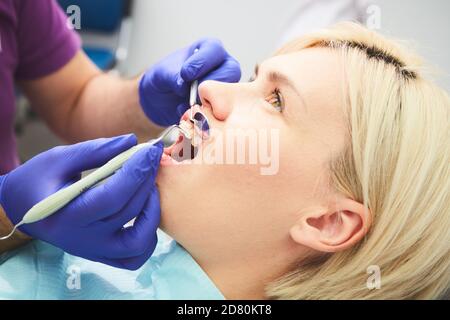 Junge lächelnde Frau mit schönen Zähnen, mit einer zahnärztlichen Inspektion Stockfoto