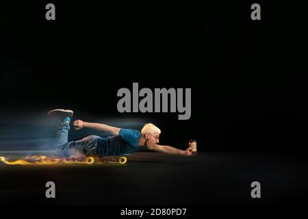 Geschwindigkeit. Schnelle Lieferung Service - deliveryman auf Skateboard fahren mit Ordnung in Feuer auf dunklem Hintergrund. Copyspace für Werbung. Super schnelle Lieferung von Lebensmitteln und Waren Bestellungen während der Quarantäne. Stockfoto