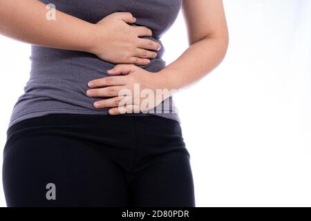 Frau mit Magenschmerzen und Verletzungen isoliert weißen Hintergrund. Gesundheitsfürsorge und medizinisches Konzept. Stockfoto