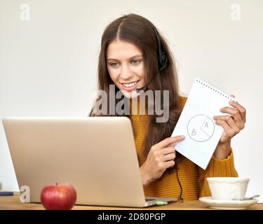 Glückliche Frau im Headset, die per Konferenzgespräch und Video spricht Chatten Sie im Büro auf einem Laptop Stockfoto