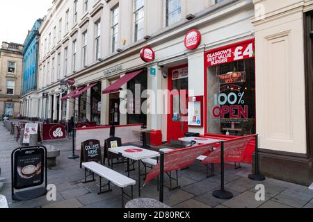 Glasgow, Schottland, Großbritannien. 26. Oktober 2020. Blick auf das Stadtzentrum von Glasgow an Wochentagen während der Schutzschalter-Sperre mit Bars und Restaurants geschlossen. Im Bild: Leere Tische vor dem Café am Royal Exchange Square. Iain Masterton/Alamy Live News Stockfoto