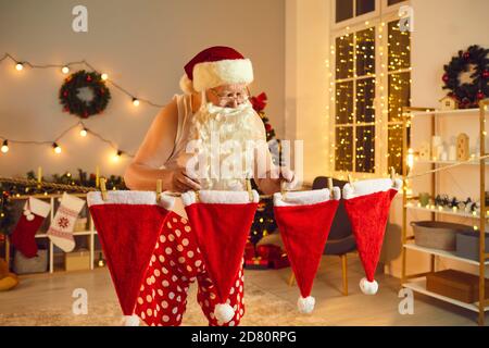 Weihnachtsmann hängend seine Hüte auf Wäscheleine trocknen Nach der Wäsche in den Winterferien Stockfoto