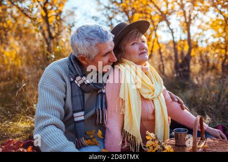 Ältere Familienpaar entspannen im Herbstwald. Glücklicher Mann und Frau genießen Picknick und Naturlandschaft Stockfoto