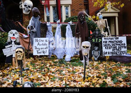 Ottawa, Kanada. Oktober 2020. Covid 19 Themen Halloween Dekorationen an der Vorderseite eines Hauses in der Glebe. Skelett trägt eine Maske, und in kanadischer Mode bitten die Menschen, einen Hockeyschläger auseinander zu halten für soziale Distanzierung. Mit Oktober 31 nähern Ottawa Public Health sowie die Regierung von Ontario haben die Menschen gebeten, ihre Trick oder Behandlung Pläne in diesem Jahr stornieren, und stattdessen organisieren haushaltsspezifische Aktivitäten. Kredit: Meanderingemu/Alamy Live Nachrichten Stockfoto