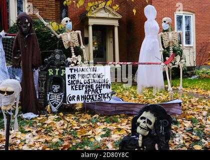 Ottawa, Kanada. Oktober 2020. Covid 19 Themen Halloween Dekorationen an der Vorderseite eines Hauses in der Glebe. Skelett trägt eine Maske, und in kanadischer Mode bitten die Menschen, einen Hockeyschläger auseinander zu halten für soziale Distanzierung. Mit Oktober 31 nähern Ottawa Public Health sowie die Regierung von Ontario haben die Menschen gebeten, ihre Trick oder Behandlung Pläne in diesem Jahr stornieren, und stattdessen organisieren haushaltsspezifische Aktivitäten. Kredit: Meanderingemu/Alamy Live Nachrichten Stockfoto