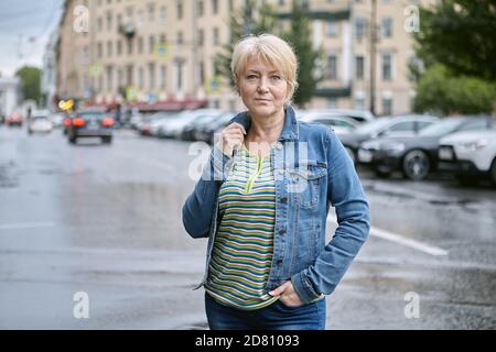 Reife Frau steht auf der Straße in der Stadt. Stockfoto