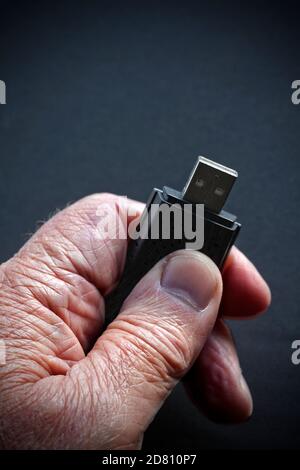Ältere Hand mit Falten halten Memory Stick Stockfoto