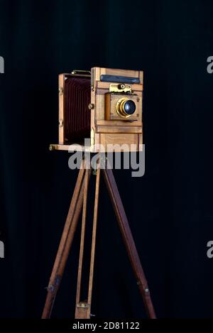 Antike Full Plate Studiokamera aus Mahagoni Holz mit Messing Beschläge Aufnahme auf schwarzem Hintergrund mit Vintage-Holz-Stativ Stockfoto