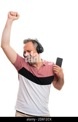 Fröhliche Erwachsene Mann Modell hält Smartphone Musik hören in Kopfhörer genießen Tanz isoliert auf weißem Studio Hintergrund Stockfoto
