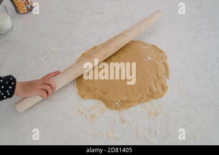 Kleines Mädchen hält Nudelholz und Kekse backen Stockfoto